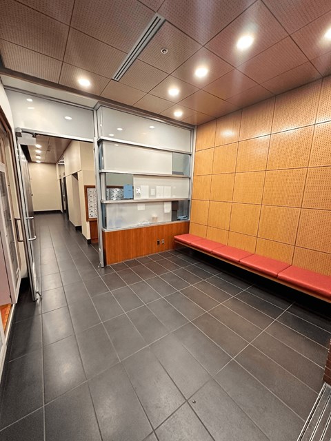 A long hallway with a bench and a wall of cabinets.