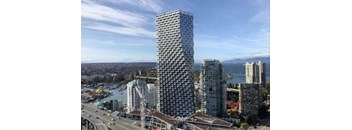 A tall, modern building with a grid-like facade stands in the foreground of a cityscape.