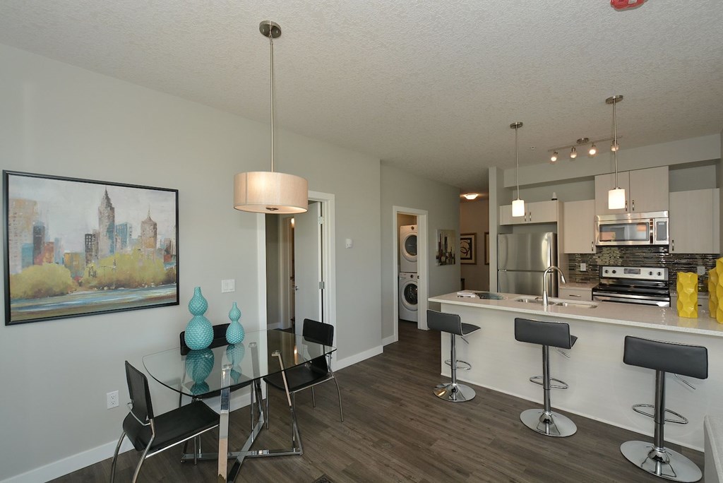 A modern kitchen with a bar area and a dining table.