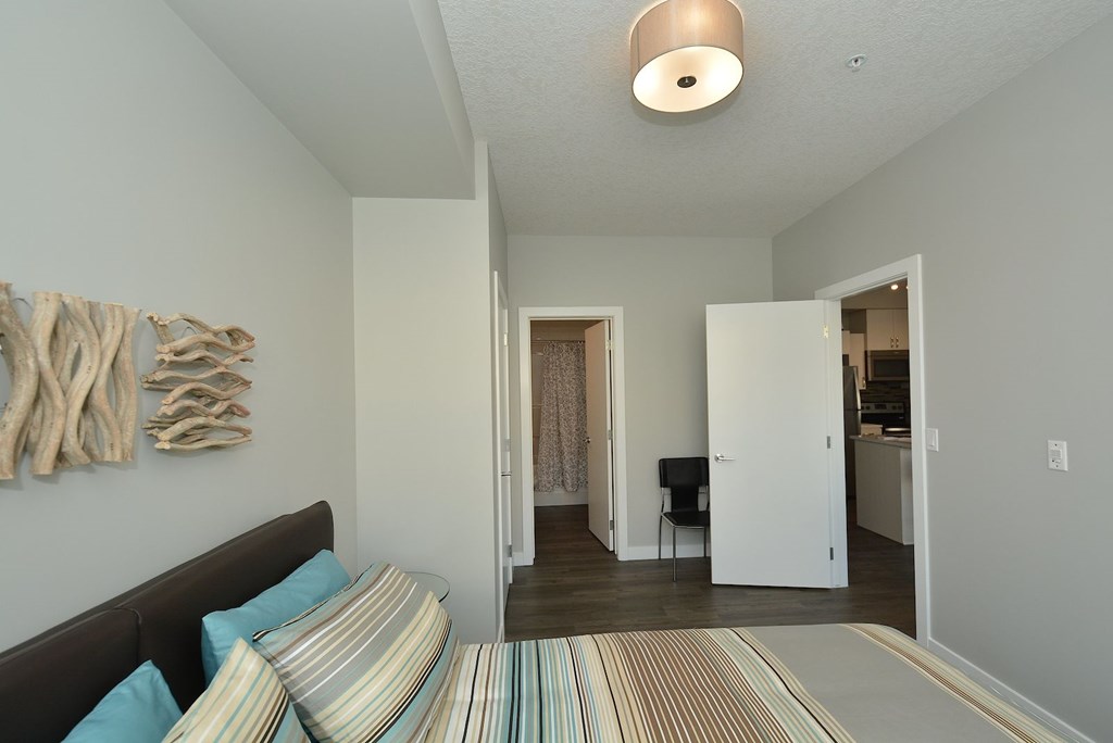 A bedroom with a bed and a chair in it.