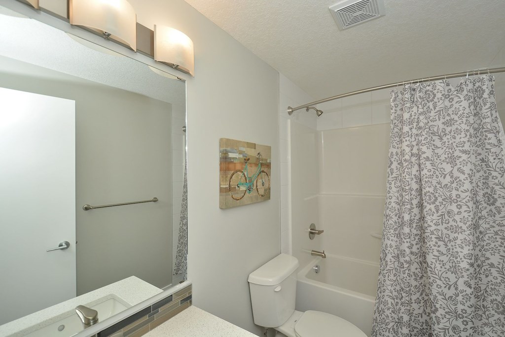 A bathroom with a toilet, sink, and shower.