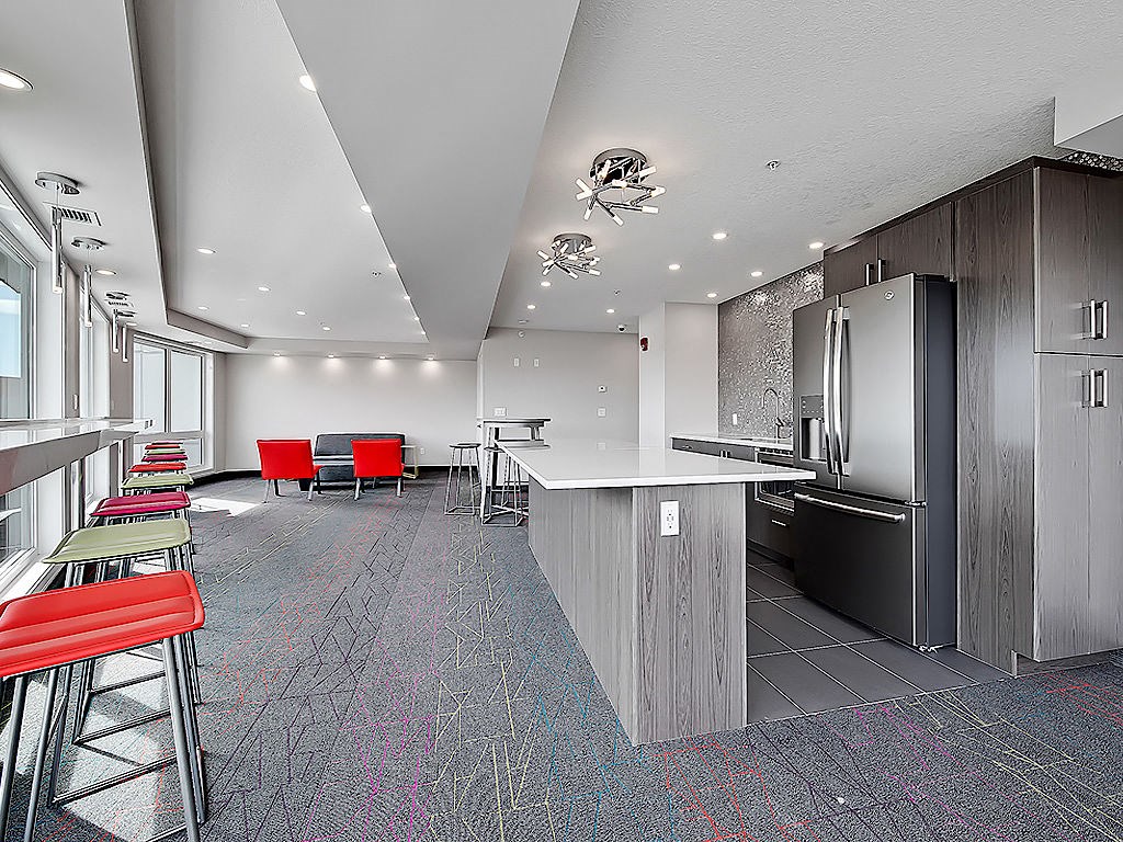 A modern kitchen with a bar area and seating.