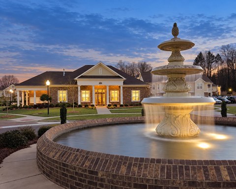 A beautiful house with a fountain in front of it.