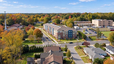 A view of a residential area with houses and a large building in the background.