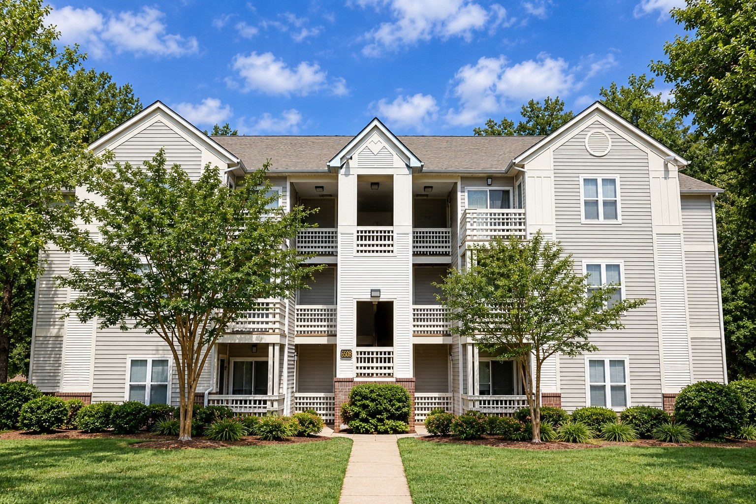 A two-story apartment building with a balcony on the second floor.
