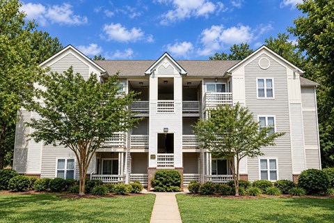 A two-story apartment building with a balcony on the second floor.