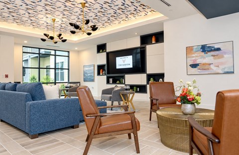 A living room with a blue sofa, a wooden chair, and a television.