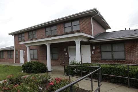 A red brick house with a white door and windows.