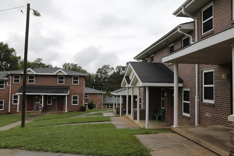 A row of houses with a grassy area in between.