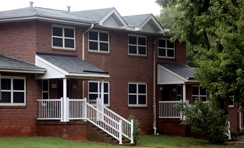 A red brick house with a white porch.