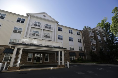 A large white building with a balcony on the second floor.