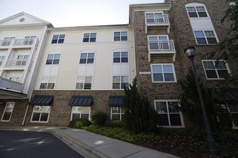 A street view of a residential building with apartment balconies.