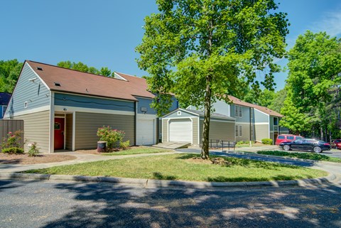 A house with a red door and a tree in front of it.