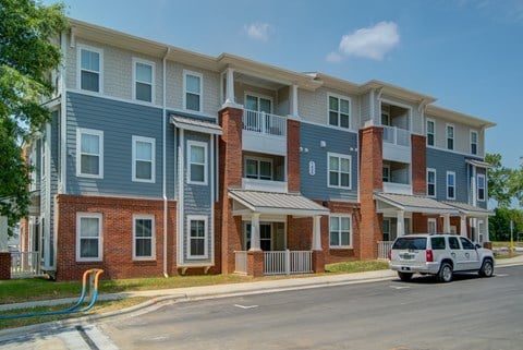 A row of townhouses with a car parked in front.