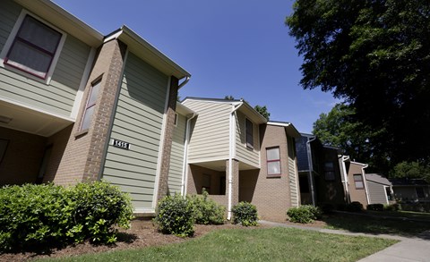 Apartment building with green bushes in front.