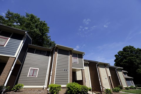 A row of houses with the first one having a red window.