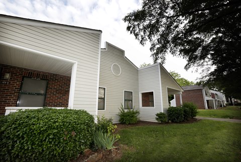 A house with a white siding and a brick chimney.