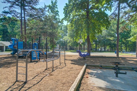 A playground with a seesaw, swings, and a slide.