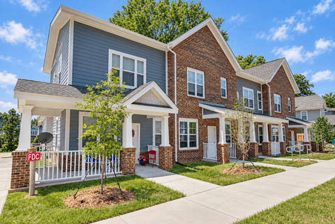 A row of houses with a sign that says FDC in front of the first one.