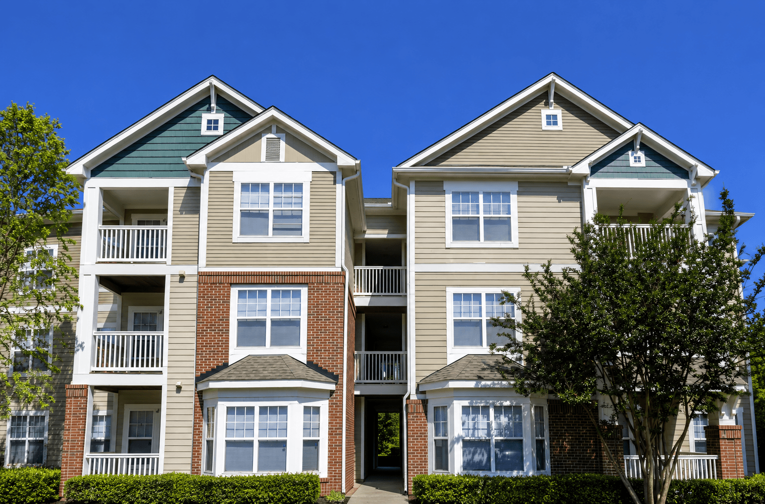 A large two-story apartment building with balconies and multiple windows.
