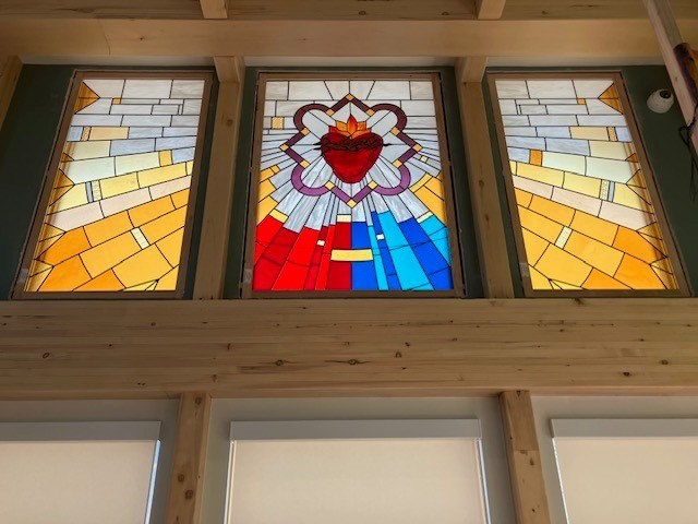 Three stained glass windows with a central flower design.