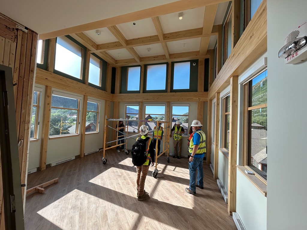Three construction workers are in a room with wooden floors and walls under construction.at Benedict, The, GLENWOOD SPRINGS, CO 81601