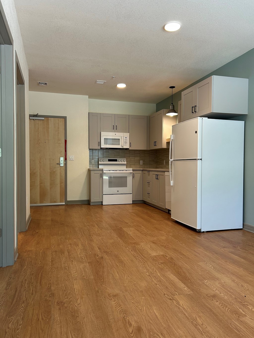 A kitchen with a refrigerator, oven, and microwave.at Benedict, The, Colorado