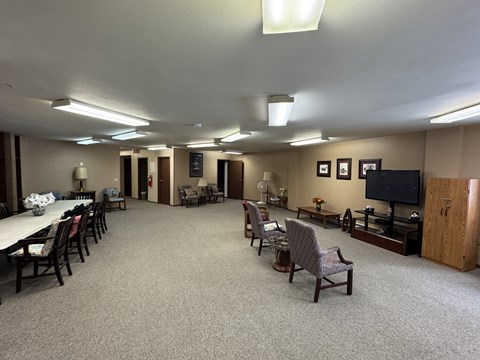 A spacious room with a long table and chairs.