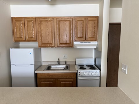 A kitchen with wooden cabinets and white appliances.