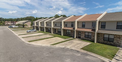 A row of houses with a car parked in front of the first house.