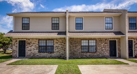 A two-story house with a mix of siding and brick exterior.