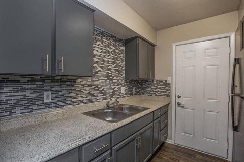 A kitchen with a sink and a white door.