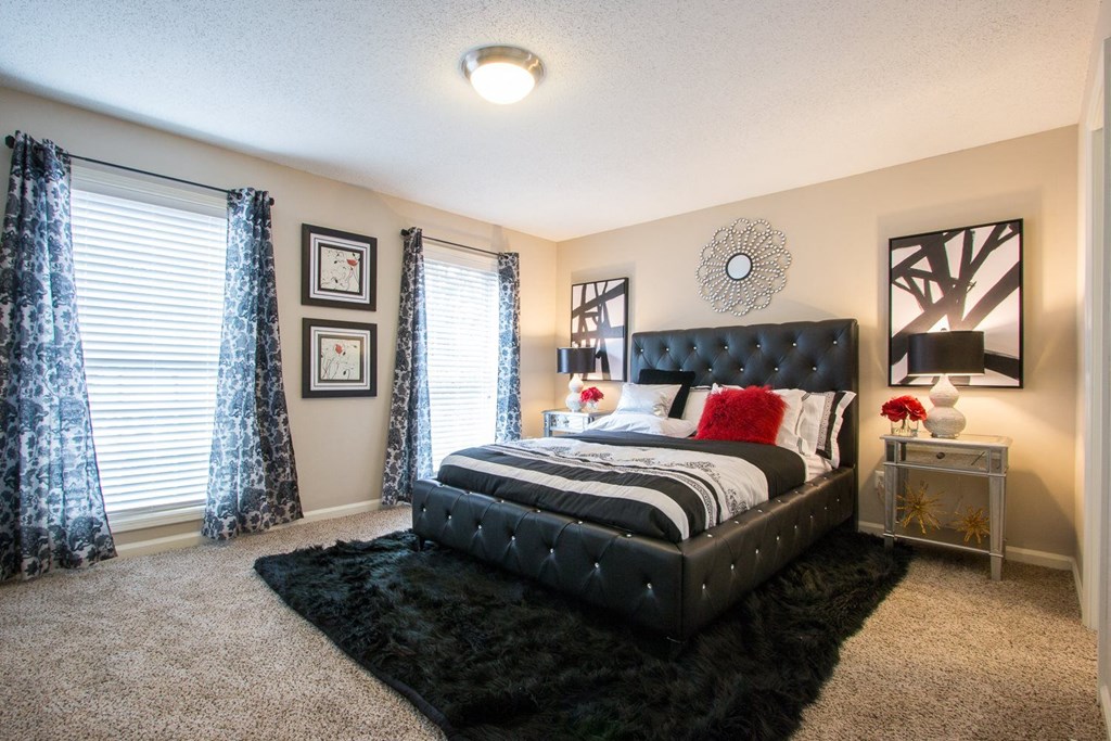 a bedroom with a bed and windows with blue curtains