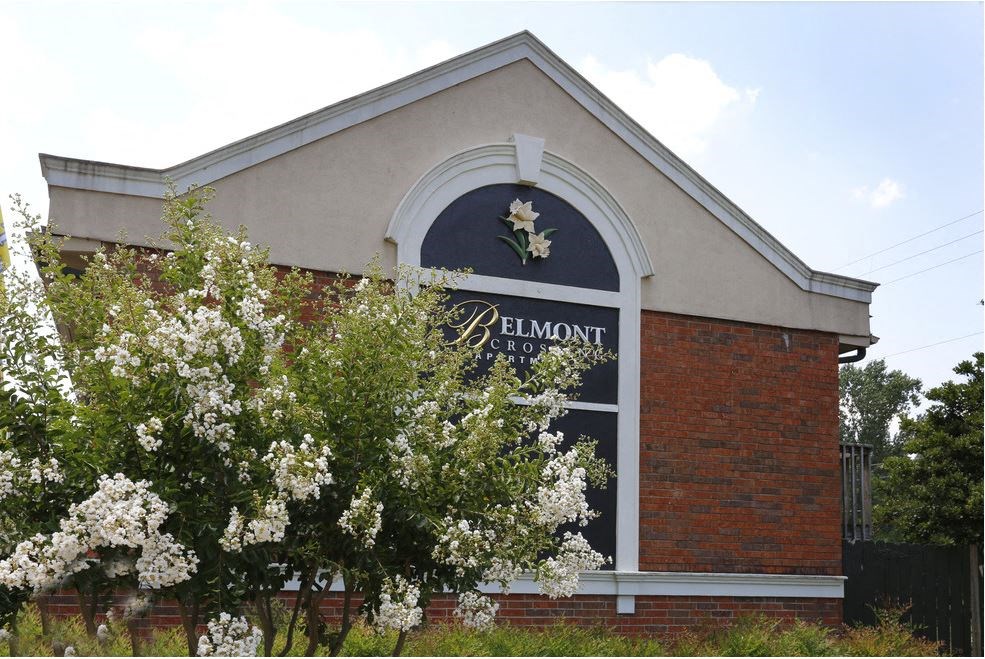 the front of a church with a window and flowering trees