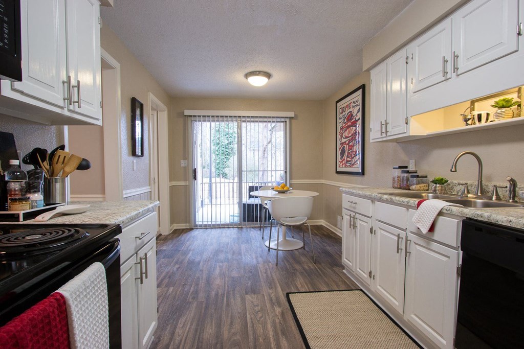a kitchen with white cabinets and a sink and a chair