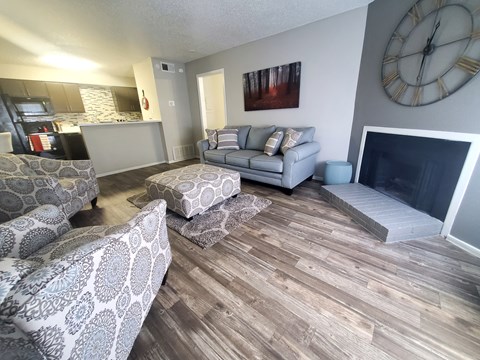 A living room with a grey couch and a fireplace.