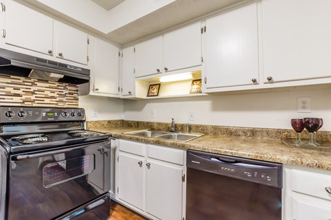 a kitchen with white cabinets and stainless steel appliances and granite counter tops