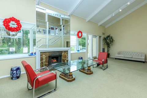 A living room with a red chair and a glass table.