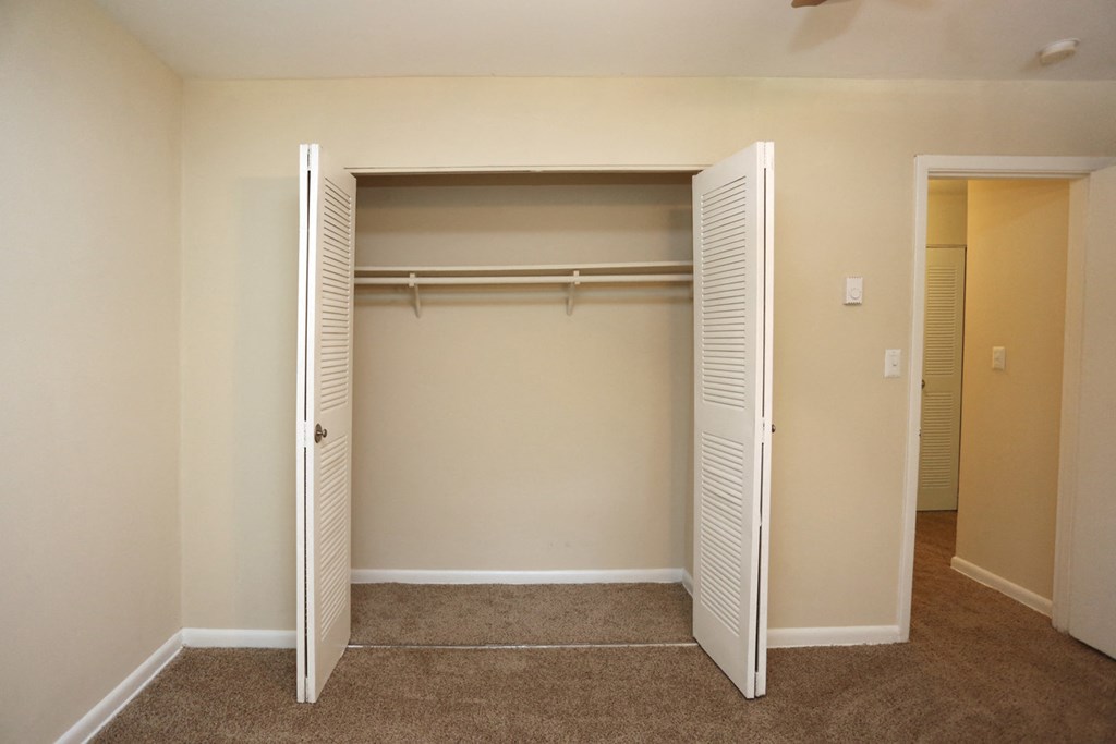 an empty closet in an empty room with closet doors