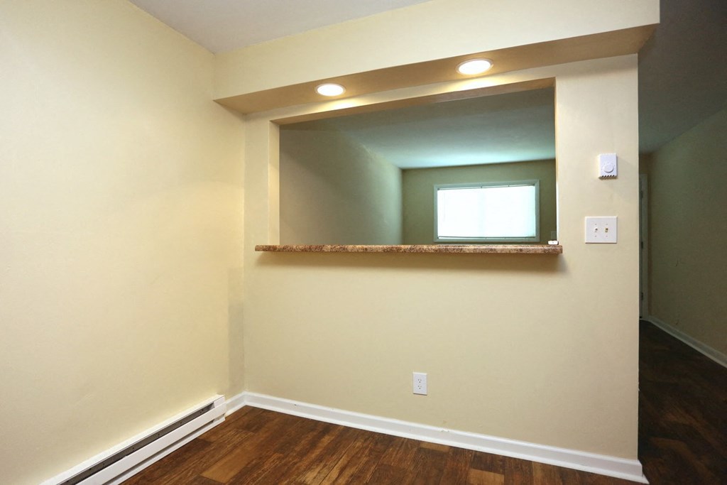 a room with a mirror on the wall and a wooden floor