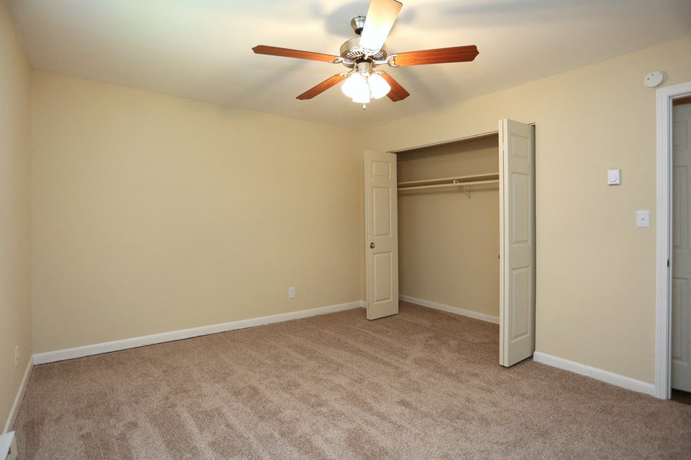a bedroom with a ceiling fan and a closet