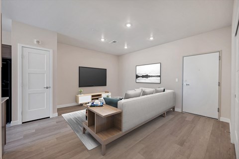 A living room with a grey couch and a wooden coffee table.