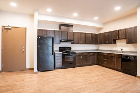a kitchen with black appliances and dark wood cabinets