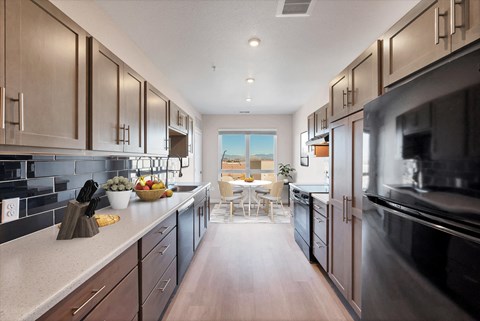 A modern kitchen with dark wood cabinets and stainless steel appliances.