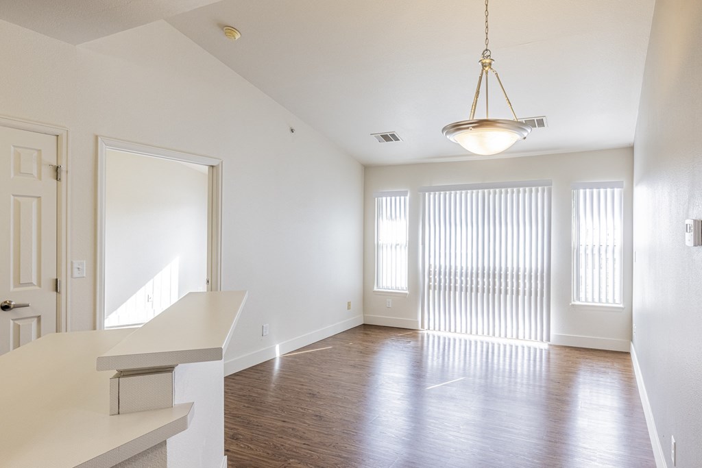 A view of the living room with vinyl planking floors and large sliding glass door
