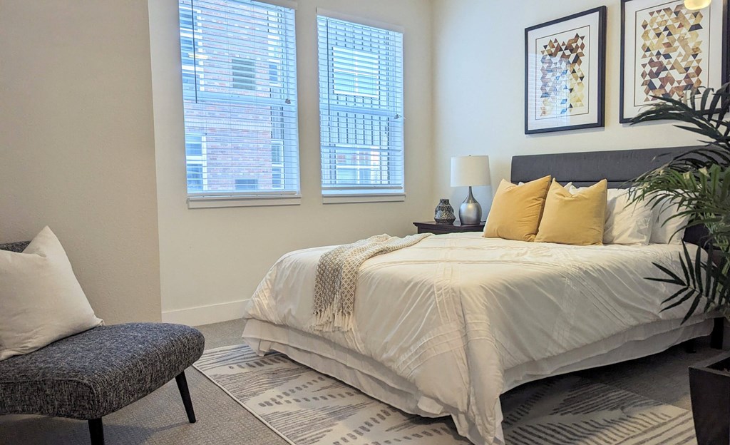 a bedroom with a bed and two windows