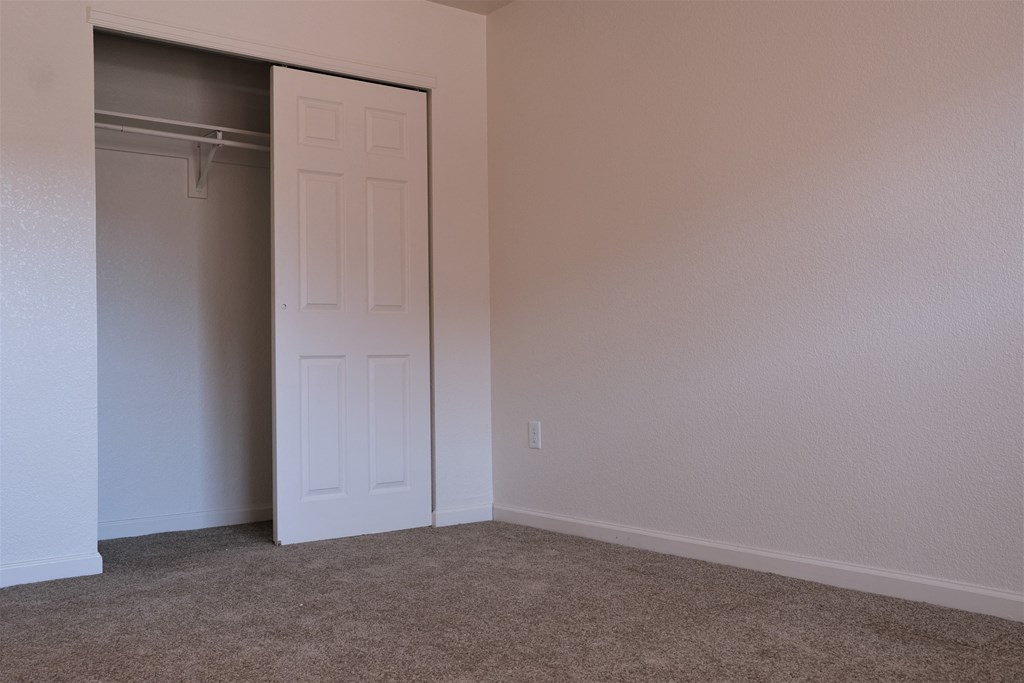 A bedroom with carpet  and sliding door closet