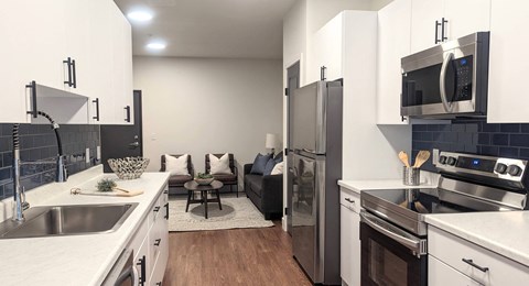 a kitchen and living room with a stainless steel refrigerator