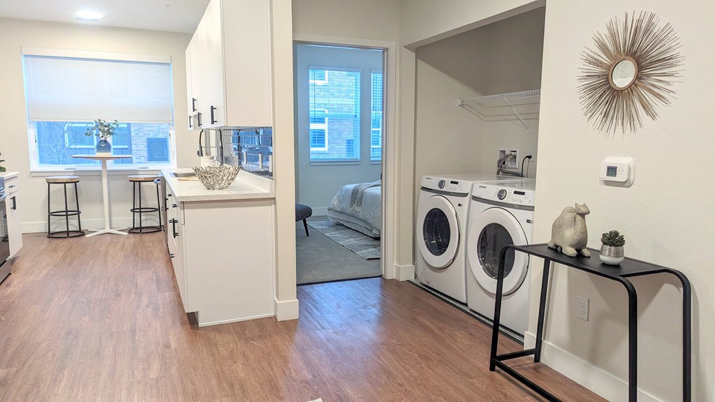 a laundry room with a washer and dryer and a bedroom with a window