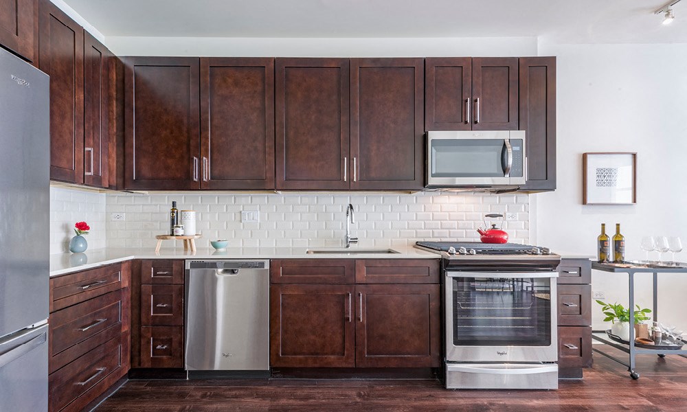 wood cabinets and Whirlpool stainless steel appliances in an apartment kitchen